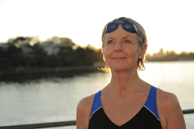 Woman wearing swimsuit and goggles looking out  