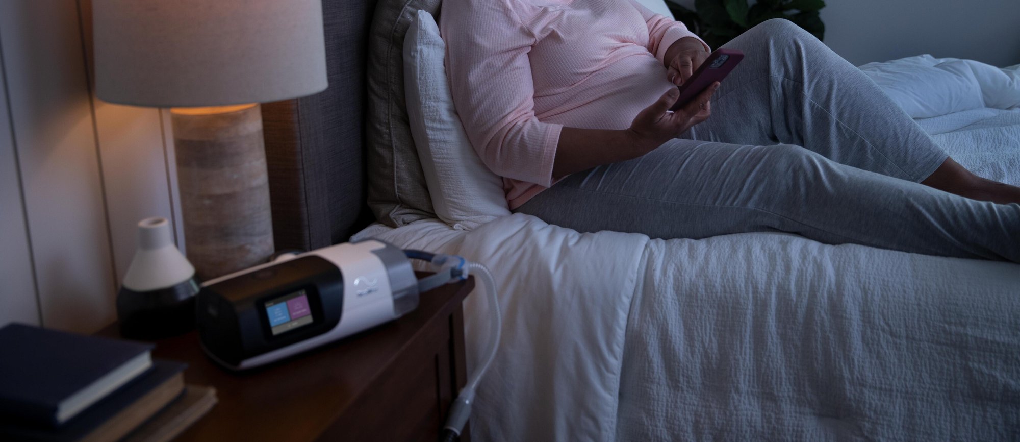 Man and woman in bed, man is snoring and the woman is awake looking upset