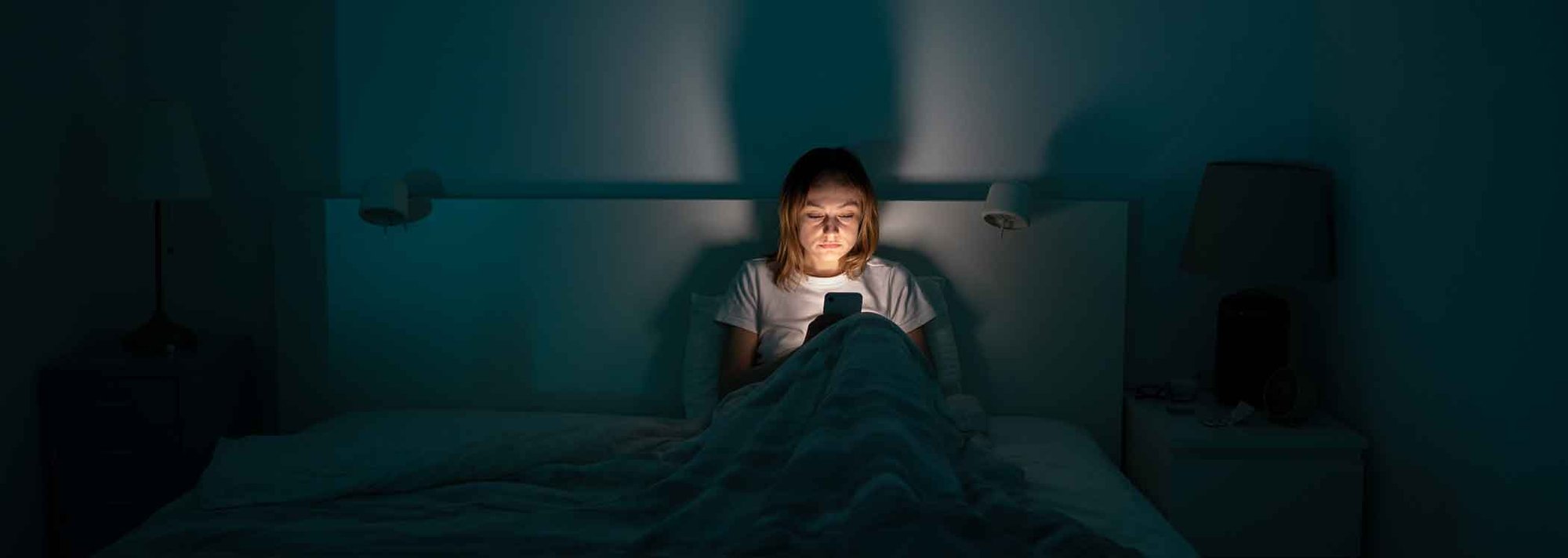 Women-on-phone-in-bed-with-insomnia