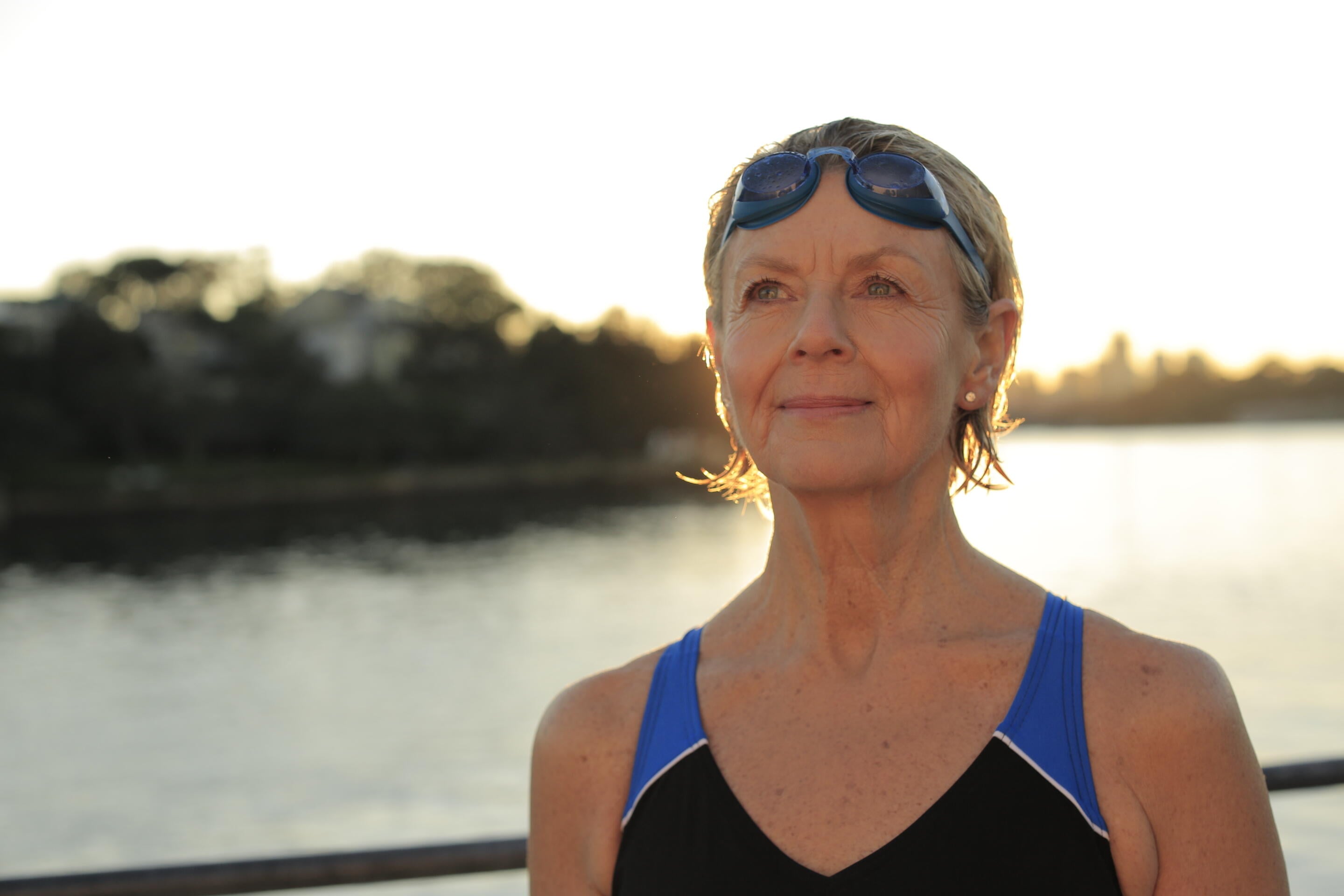Woman wearing swimsuit and goggles looking out  