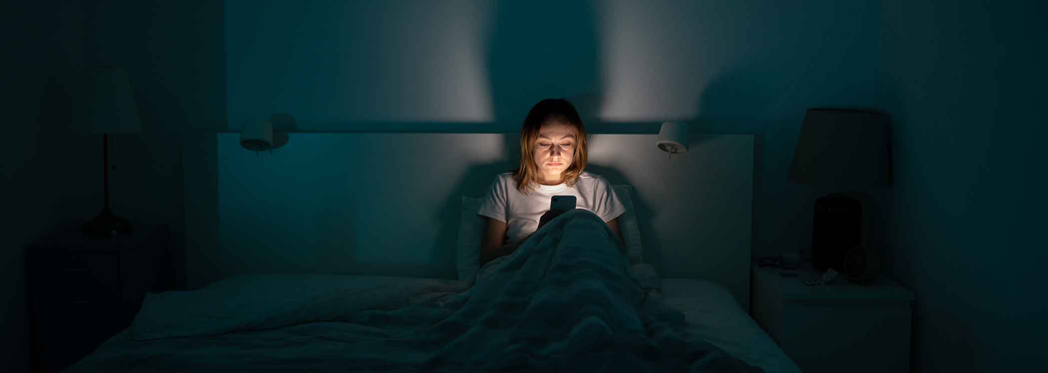 Women-on-phone-in-bed-with-insomnia