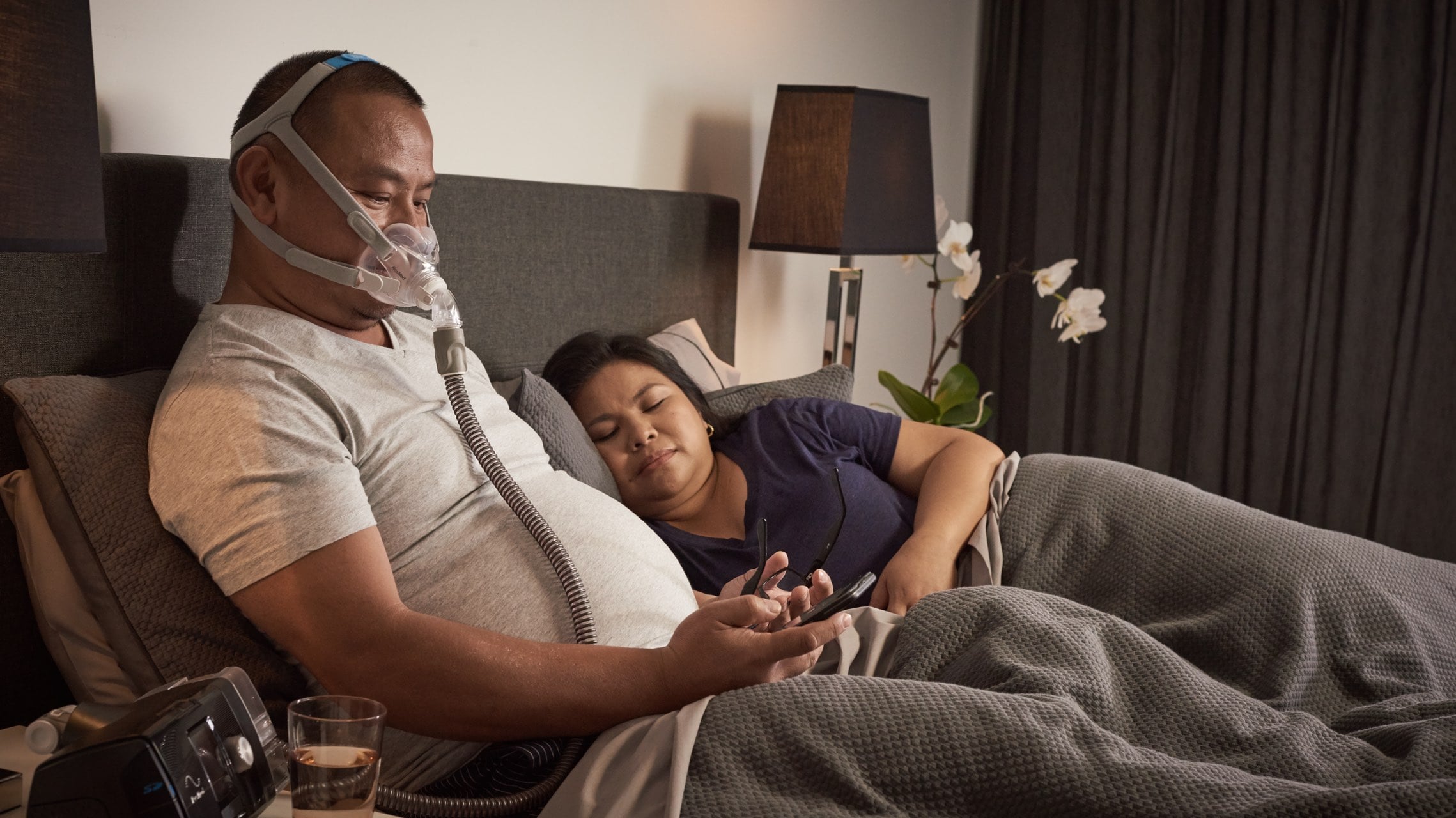 Man in bed with partner using CPAP Therapy